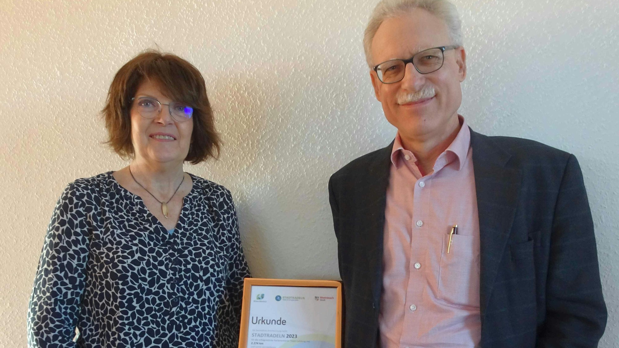 SPD-Fraktionsvorsitzende Martina Koch und ihr Stellvertreter Dr. Georg Wilmers zeigen die Urkunde zur Auszeichnung des erfolgreichsten Teams beim Wettbewerb „Stadtradeln 2023“.