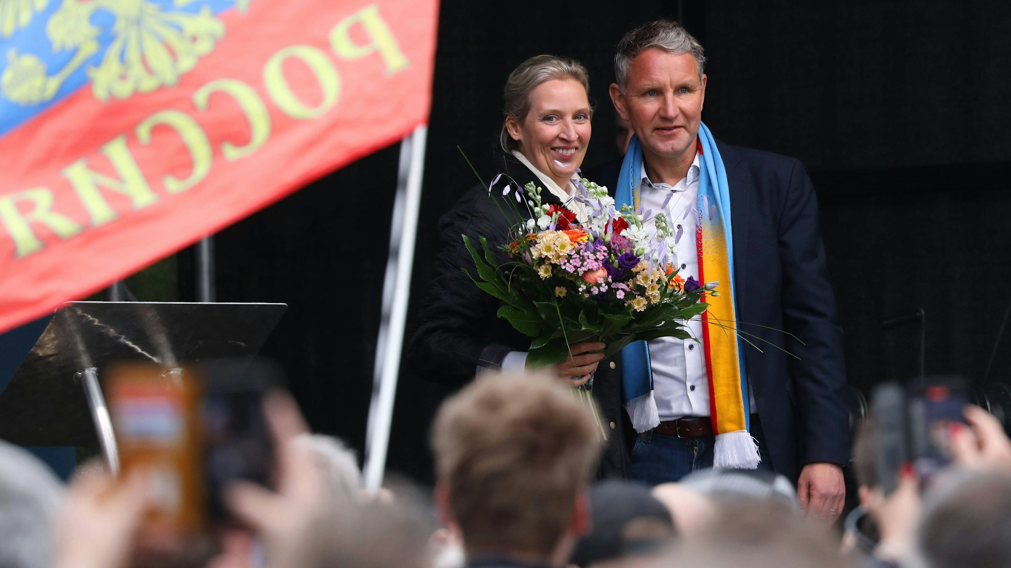 AfD-Chefin Alice Weidel zusammen mit dem Thüringer AfD-Politiker Björn Höcke bei einem Auftritt bei einer Parteiveranstaltung in Erfurt. Im Vordergrund ist eine russische Fahne zu sehen. (Archivbild)