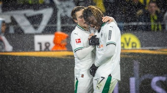 Rocco Reitz und Manu Kone schlagen im Dortmunder Stadion miteinander ein. Es regnet.