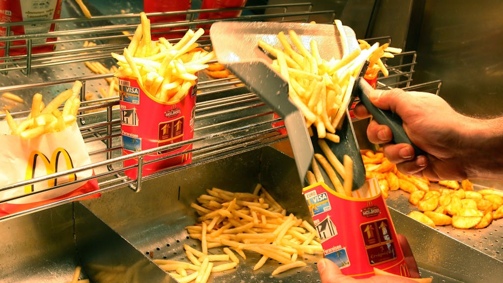 Ein Mitarbeiter der Filiale von McDonald's in Ludwigsburg füllt in der Fast-Food-Kette Pommes Frites ab, hier im Dezember 2007.