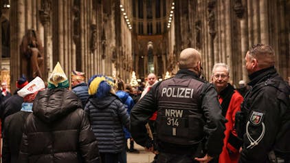 Nordrhein-Westfalen, Köln: Polizisten stehen im Dom neben Karnevalisten. Nach der Terrorwarnung für den Kölner Dom hat der Gottesdienst für die Karnevalisten unter strengen Sicherheitsvorkehrungen stattgefunden.&nbsp;