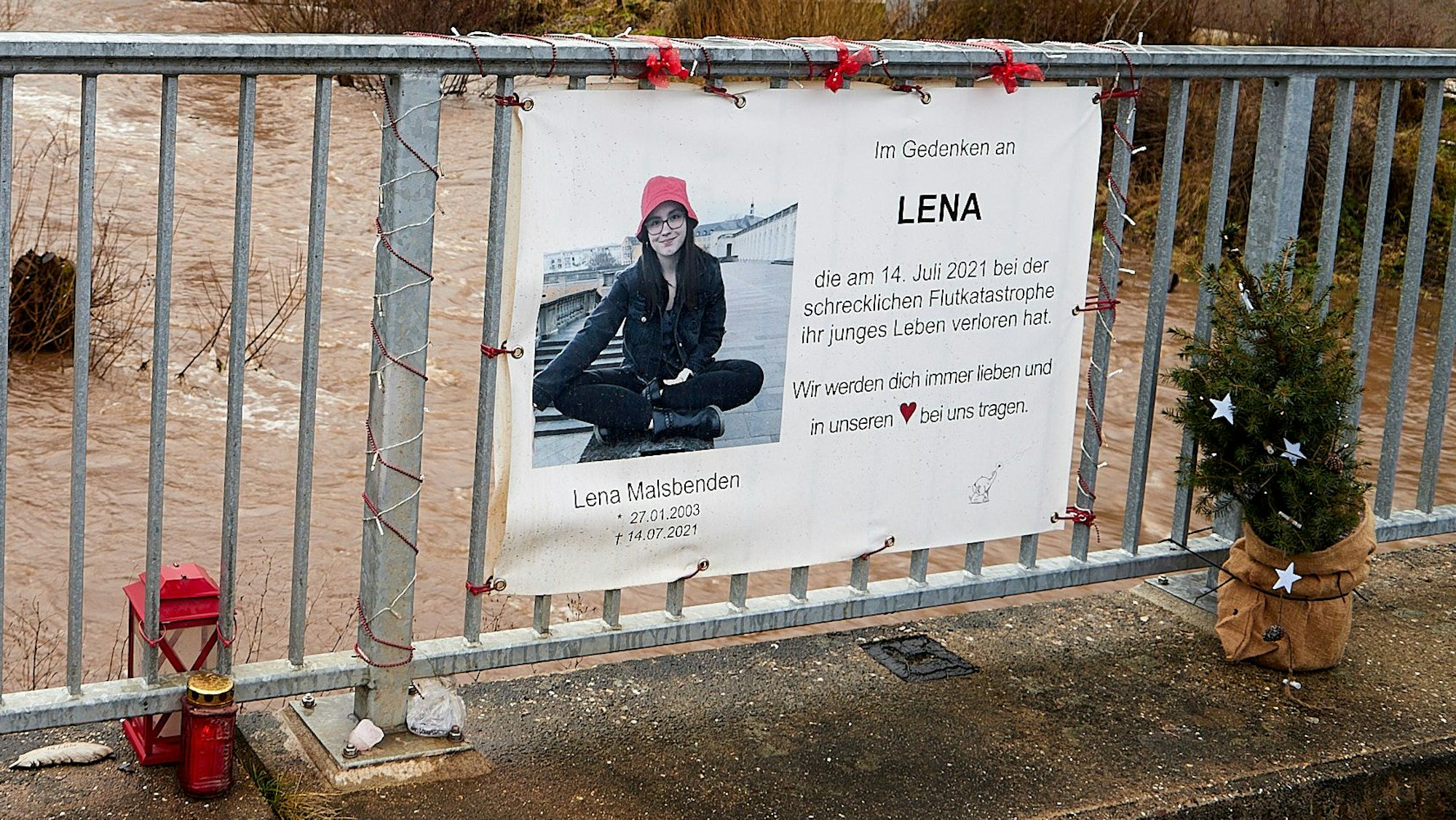 An einem Brückengeländer hängt ein Transparent mit dem Foto einer jungen Frau. Es erinnert an Lena Malsbenden, die im Alter von 18 Jahren bei der Flutkatastrophe 2021 ums Leben gekommen ist.