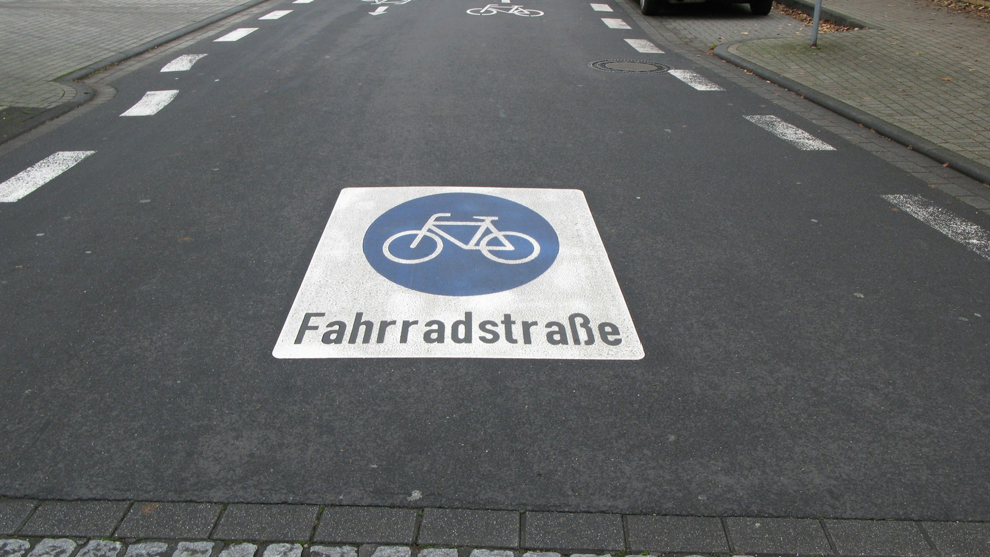 Das Piktogramm zeigt ein weißes Rechteck. Eingefügt ist ein blauer Kreis, darin ein weißes Fahrrad, darunter steht der Schriftzug „Fahrradstraße“.