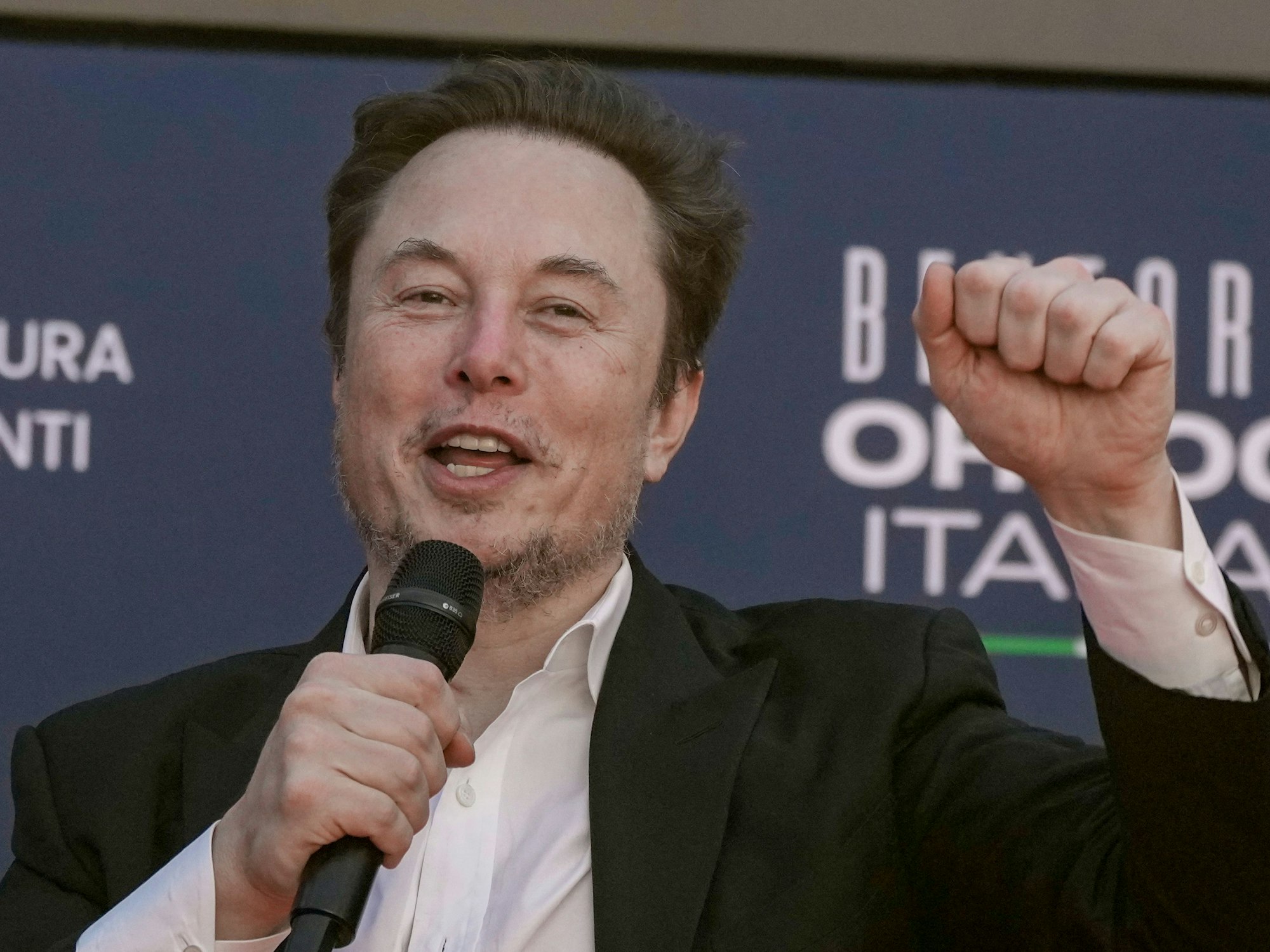 Elon Musk winkt bei seiner Ankunft auf dem jährlichen politischen Festival Atreju, das von Melonis politischer Partei Brüder Italiens organisiert wird, hier im Dezember 2023 in Rom.