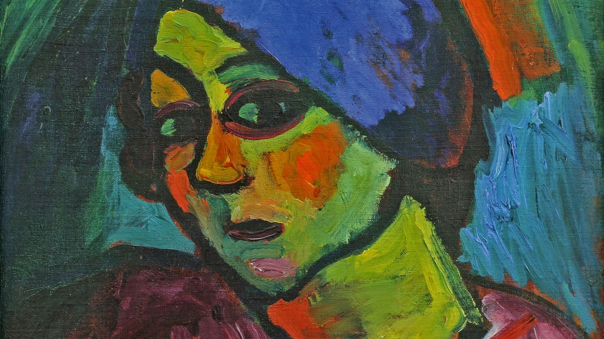Eine Frau mit grüner Haut, roten Wangen und blauem Turban schaut den Betrachter an.