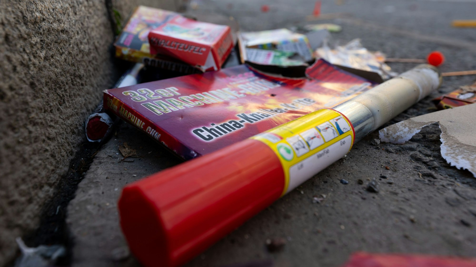 Verpackungen und abgebrannte Feuerwerkskörper liegen auf einer Straße.