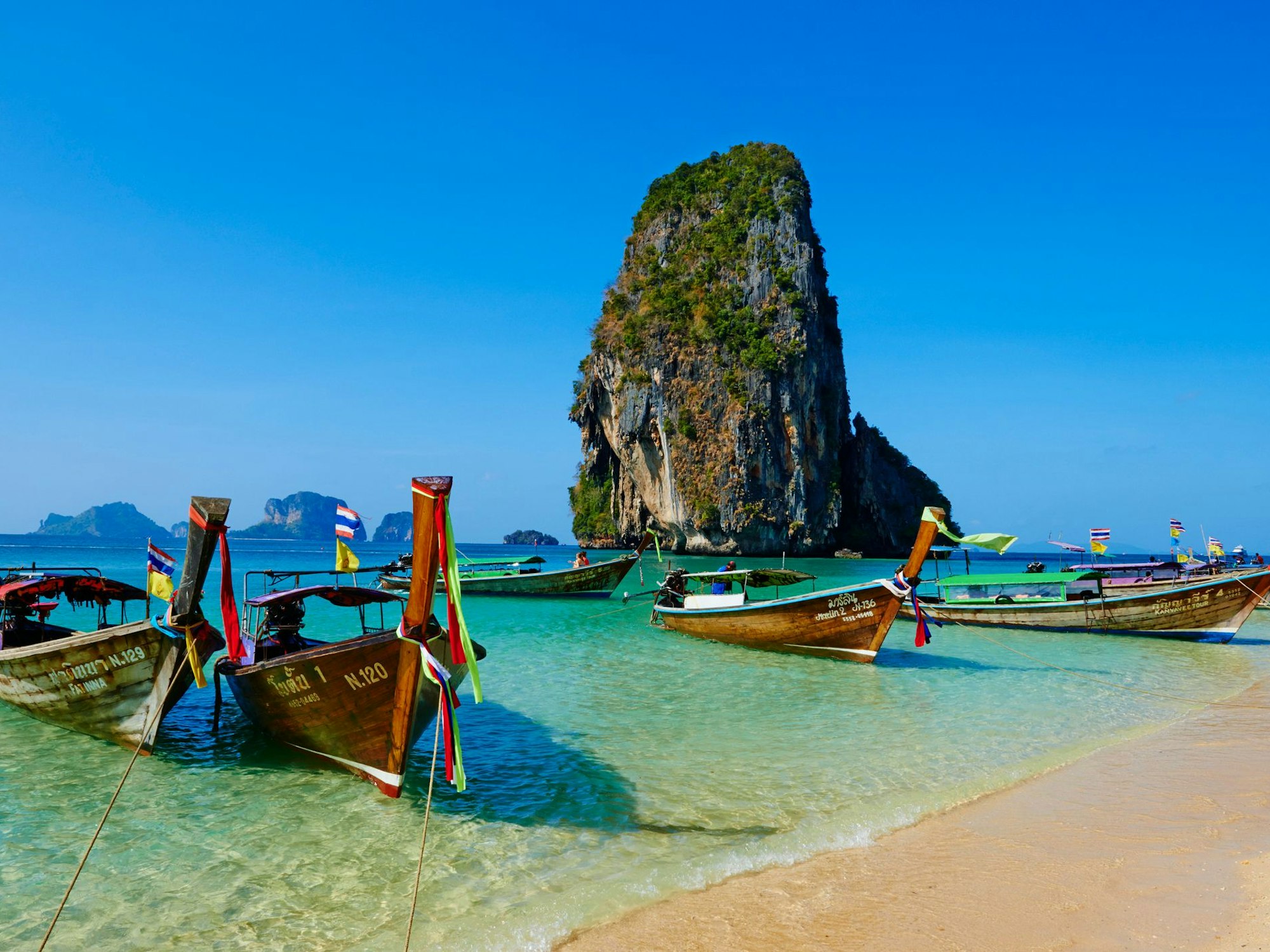 Boote liegen am Railay Strand in Thailand.