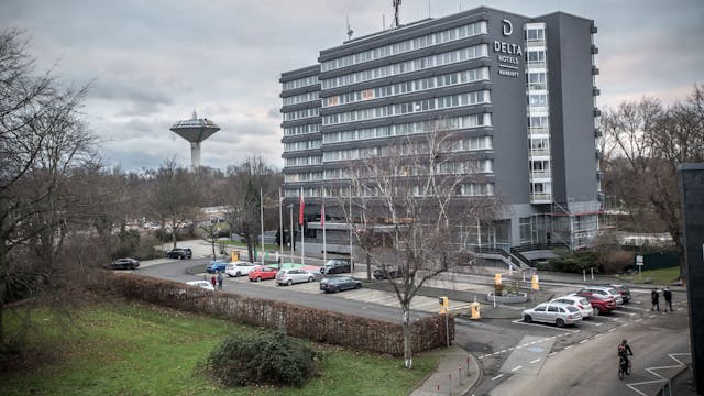 Das Delta Hotel by Marriott in Wiesdorf von außen. Vor dem Gebäude stehen Autos. Links im Hintergrund ist der Wasserturm zu sehen.