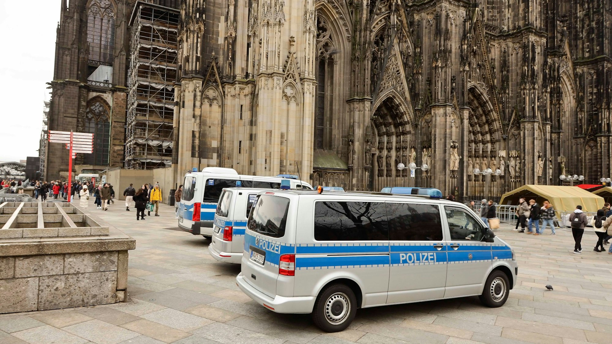 Mannschaftswagen der Polizei stehen auf der Domplatte in Köln. Im Hintergrund ist der Dom zu sehen.