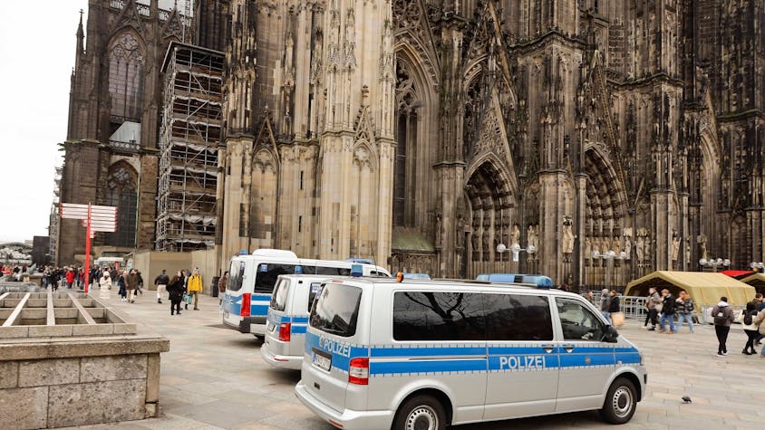 Mannschaftswagen der Polizei stehen auf der Domplatte in Köln. Im Hintergrund ist der Dom zu sehen.&nbsp;