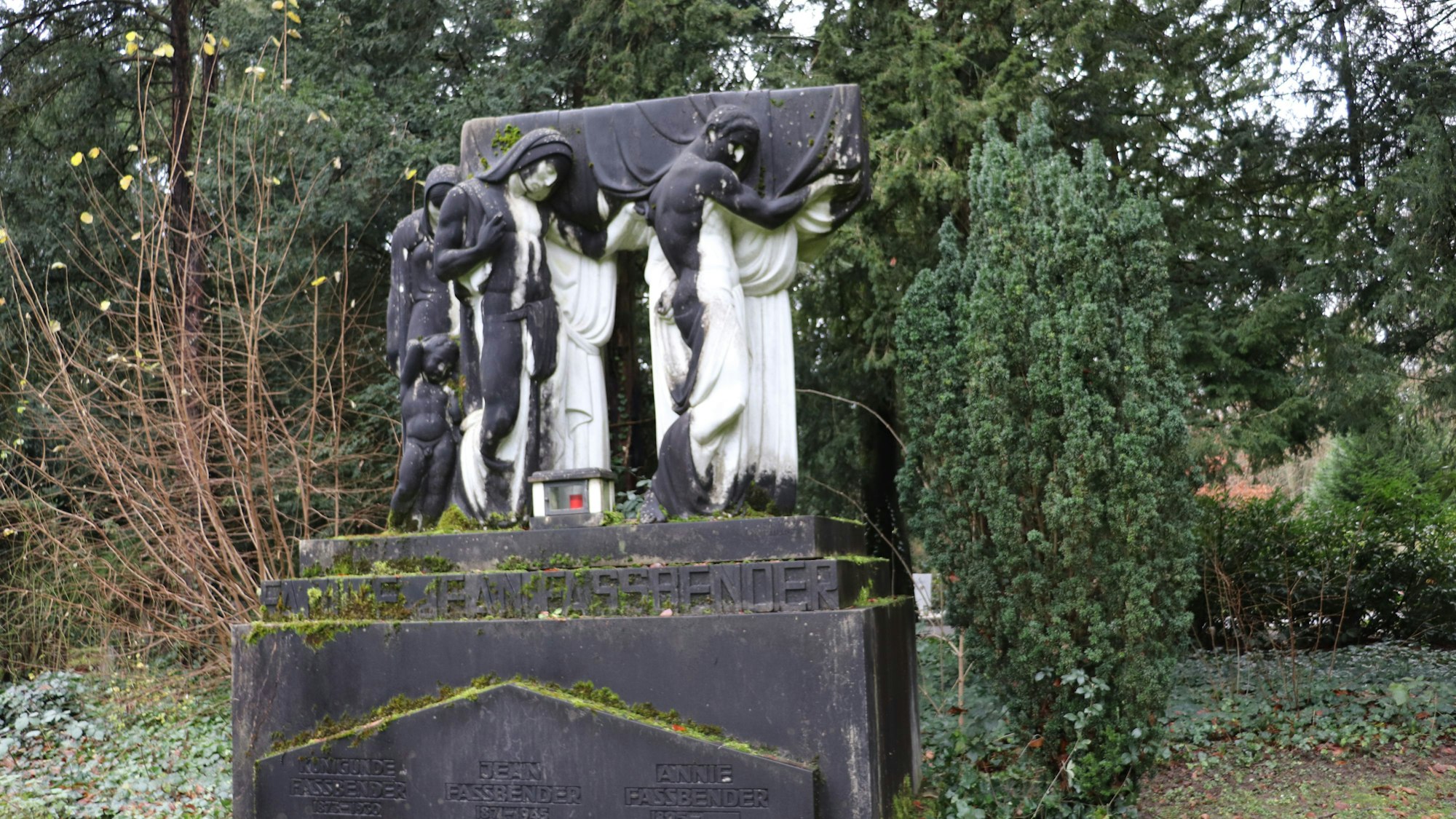 Vier weiße lebensgroße Marmorfiguren, stehn auf einem Sockel und tragen einen Sarg