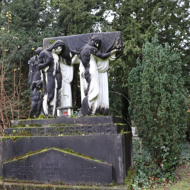 Vier weiße lebensgroße Marmorfiguren, stehn auf einem Sockel und tragen einen Sarg