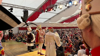 Das Kölner Dreigestirn ist von hinten auf der Bühne des Festzelts zu sehen.