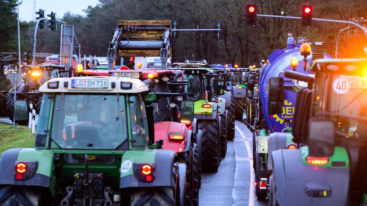Landwirte und Landwirtinnen blockieren bei einer Protestaktion mit ihren Treckern eine Autobahn-Auffahrt.