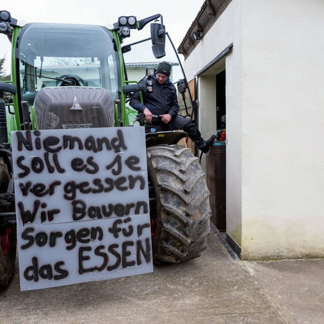 Ein Landwirt betankt seinen Schlepper mit Diesel in Vorbereitung auf die anstehende Protestwoche - am Traktor hängt bereits ein Schild mit der Aufschrift «Niemand soll es je vergessen. Wir Bauern sorgen für das Essen».