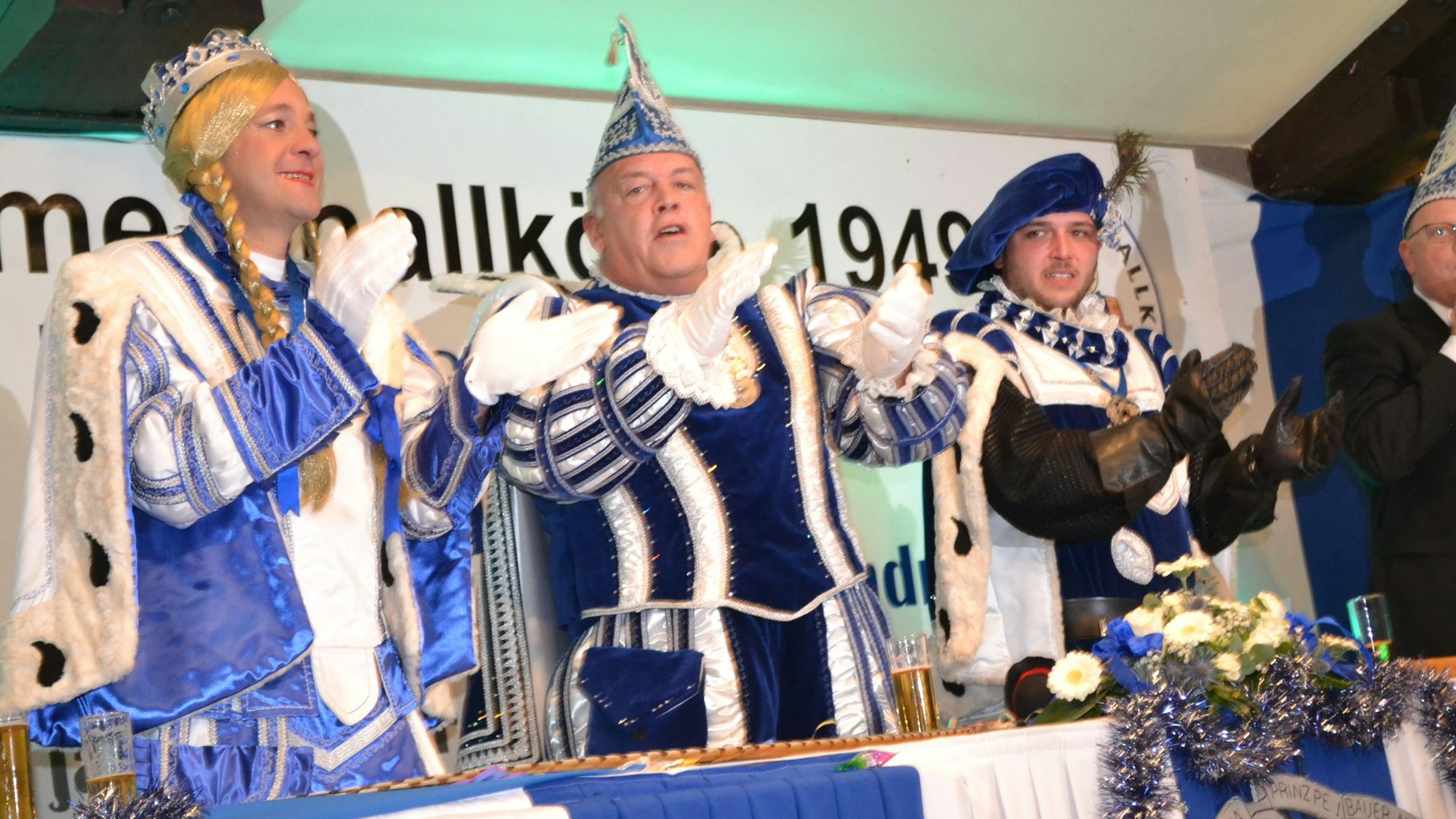 Jungfrau, Prinz und Bauer des Karnevalsdreigestirns in Blau und Weiß..