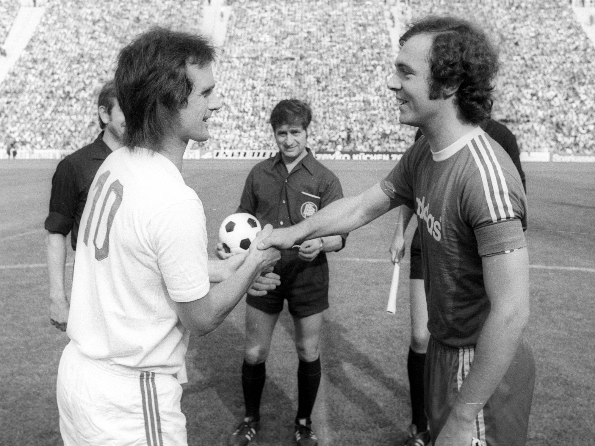 Die Kapitäne Wolfgang Overath (li., Köln) und Franz Beckenbauer (Bayern) begrüßen sich.