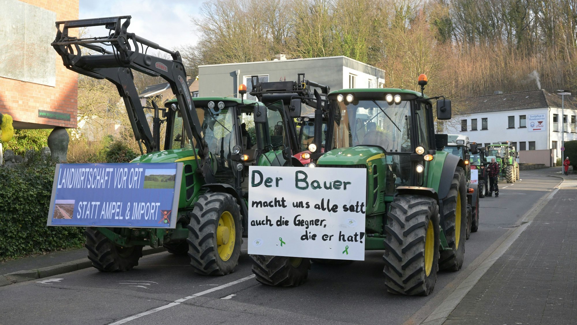 Traktoren fahren in zwei Reihen die Reuterstraße in Bergisch Gladbach herunter.