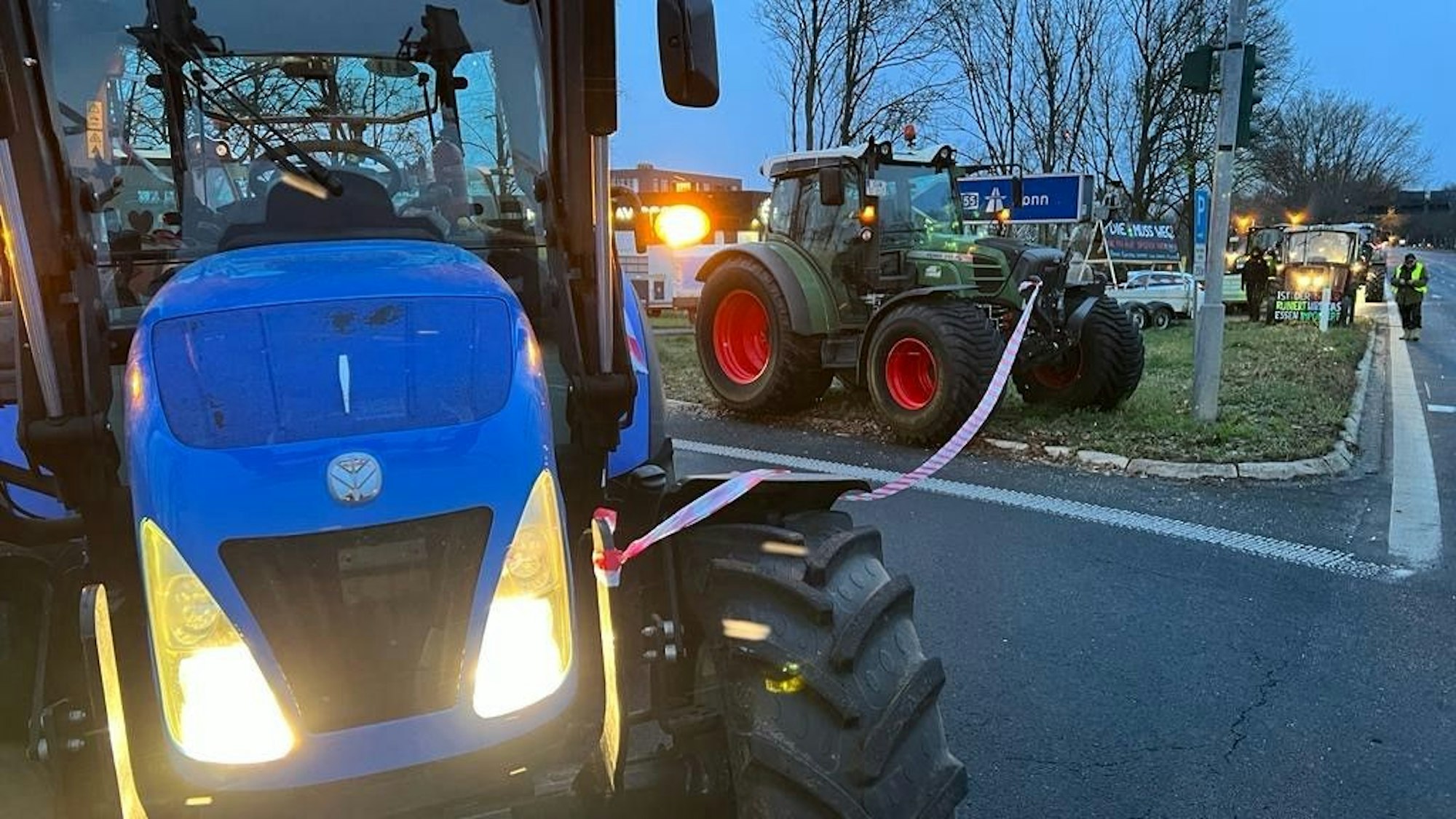 Landwirte blockieren mit Traktoren und Flatterbändern die Auffahrt zur A555 in Wesseling.
