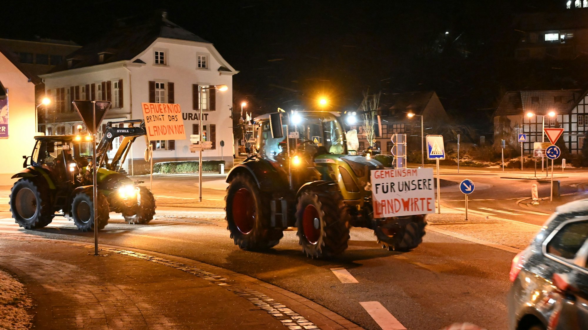 Zwei Traktoren mit Protestplakaten fahren durch Schleiden.