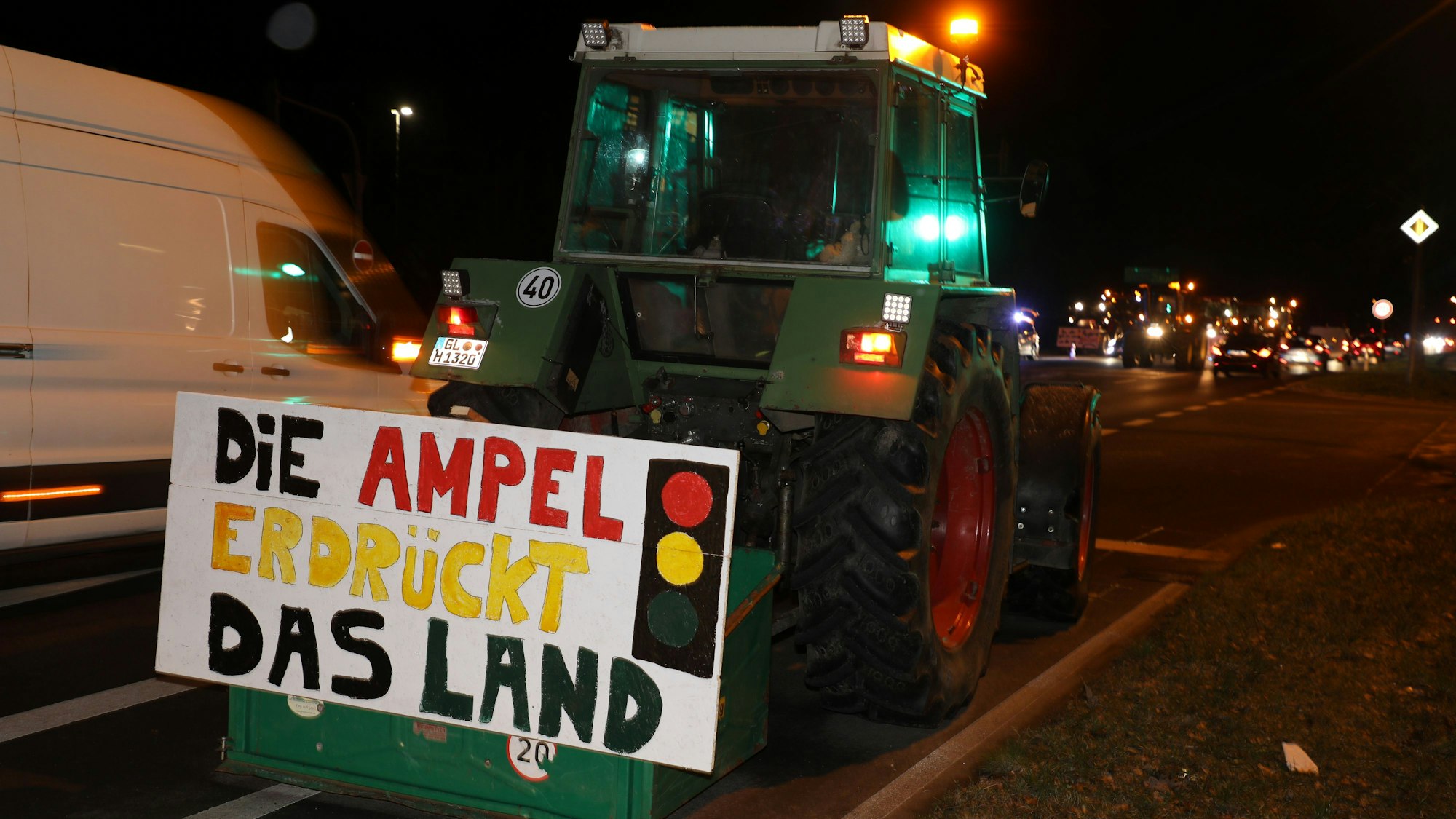 Ein Traktor mit einem Protestplakat steht an der A4-Auffahrt in Overath