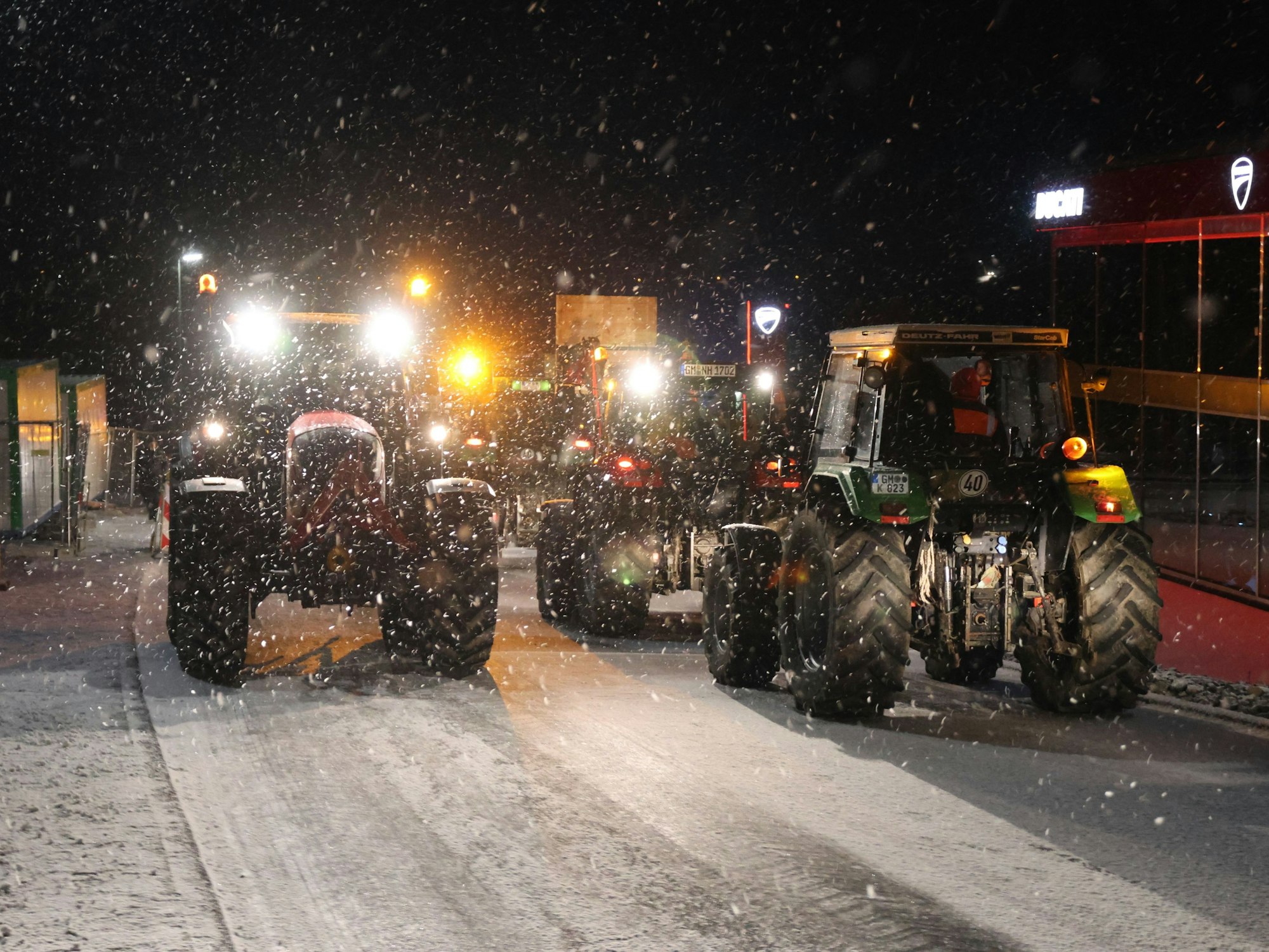 Mehrere Traktoren im Schneegestöber.