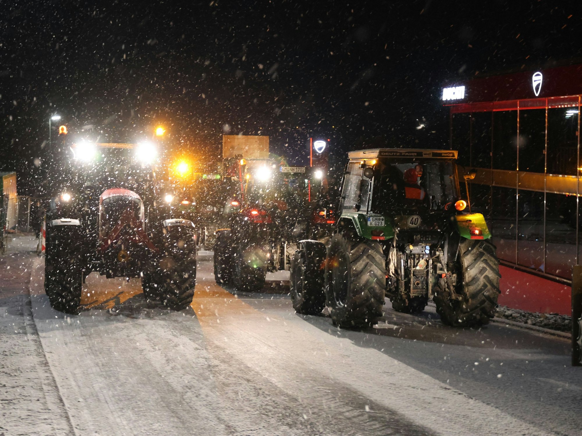 Mehrere Traktoren im Schneegestöber.