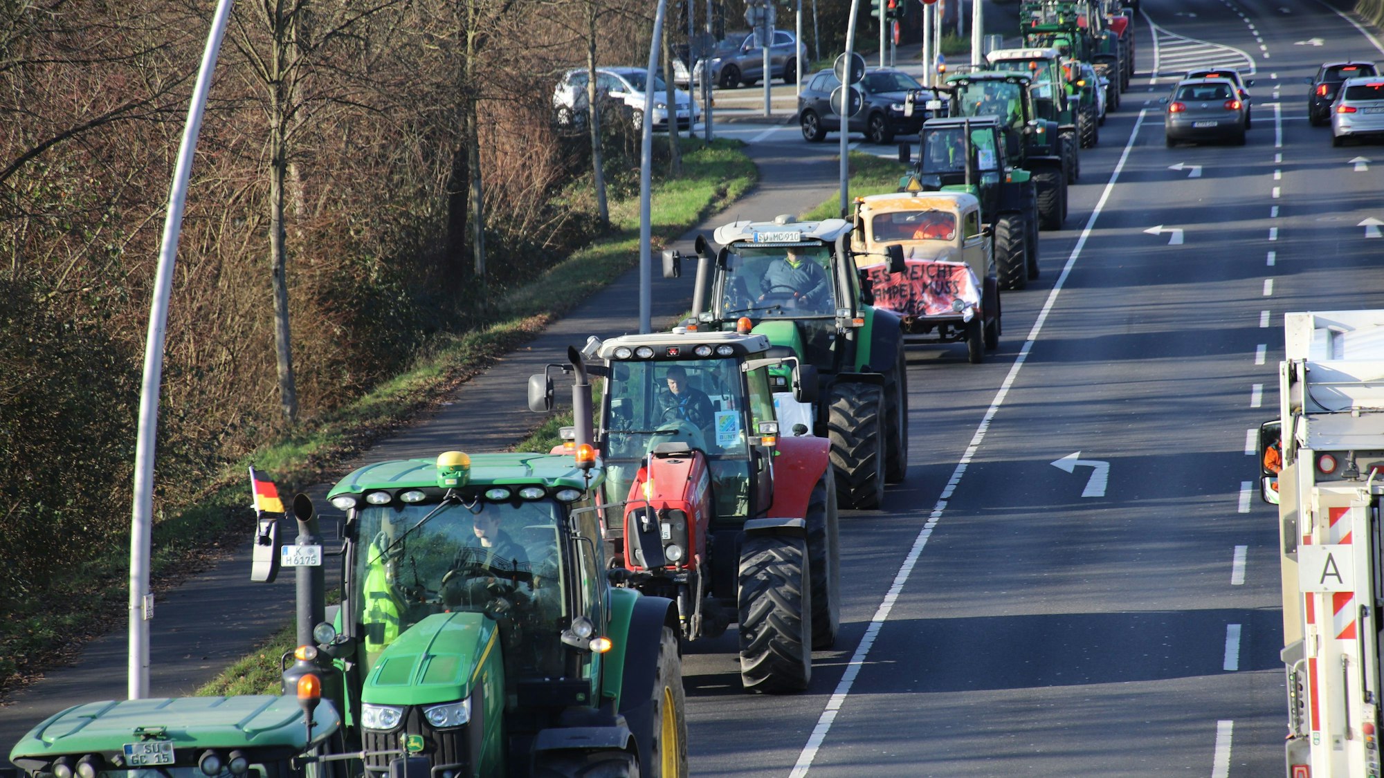 Bauernproteste im Rhein-Sieg-Kreis Anfang Januar. Mehrere Traktoren fahren in einer Reihe auf der Straße.