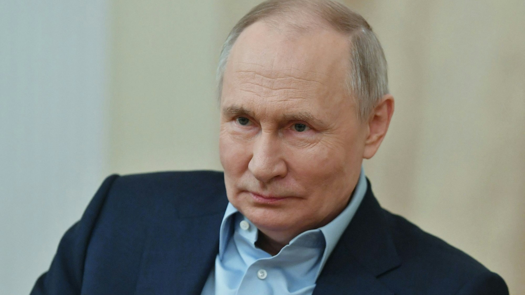 Eine Nahaufnahme des russischen Präsidenten Vladimir Putin. Er trägt einen Anzug und ein hellblaues Hemd.