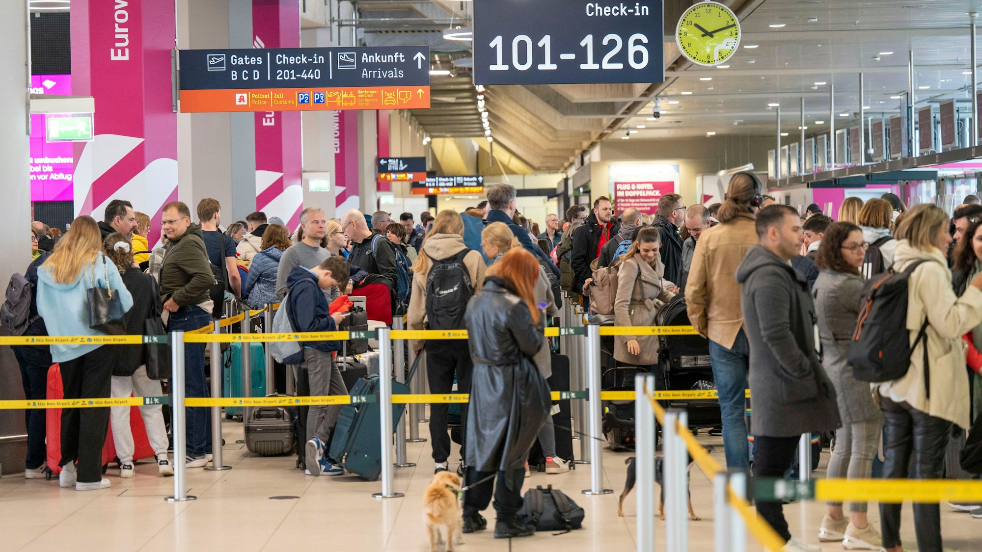Foto von Reisenden am Flughafen Köln/Bonn, die am Check-in warten.