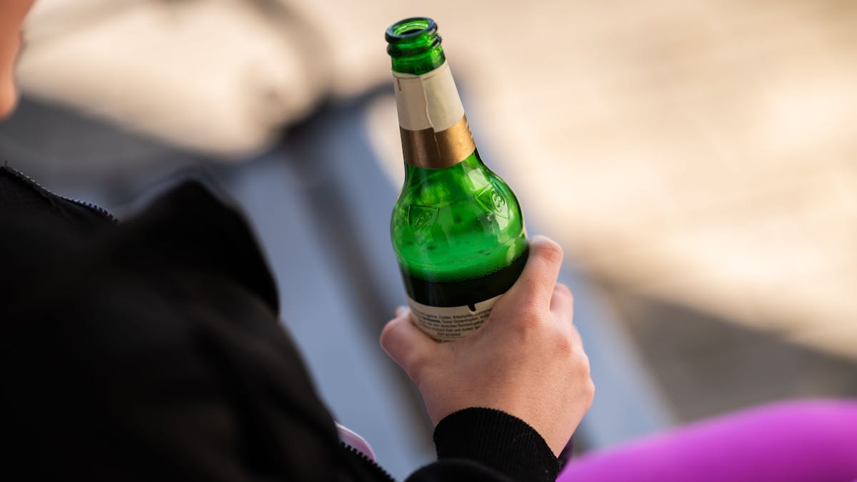Eine Person hält eine Flasche Bier in der Hand, hier im März 2022 in Rottweil.