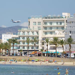 Ein Flugzeug ist hinter der Playa de Palma auf Mallorca zu sehen (Symbolbild). Die britischen Seniorinnen Linda Trestrail und Wendy Russell kamen hier zunächst nicht an.