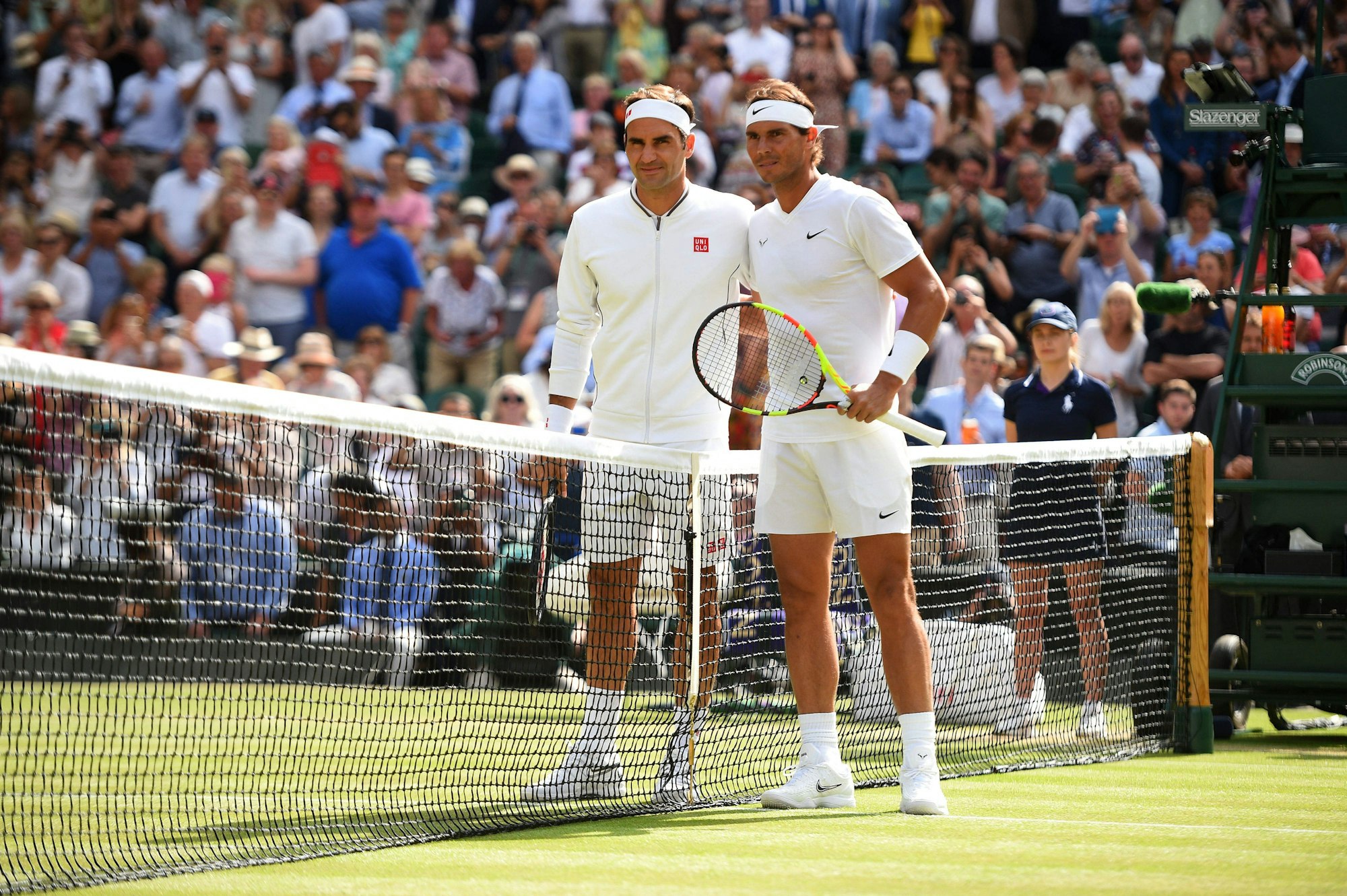 Rafael Nadal und Roger Federer posieren am Netz für ein Foto.