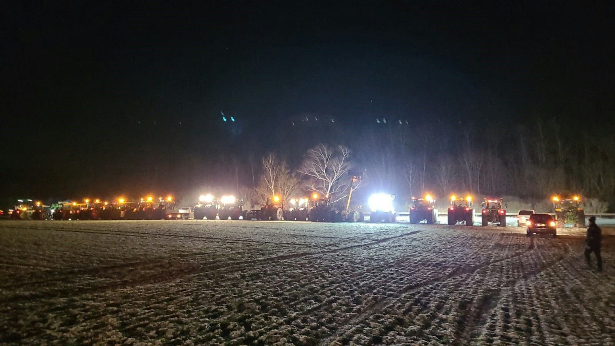 Zahlreiche Traktoren sind an der B266 bei Strempt geparkt, wo ein weiteres Mahnfeuer entzündet wurde.