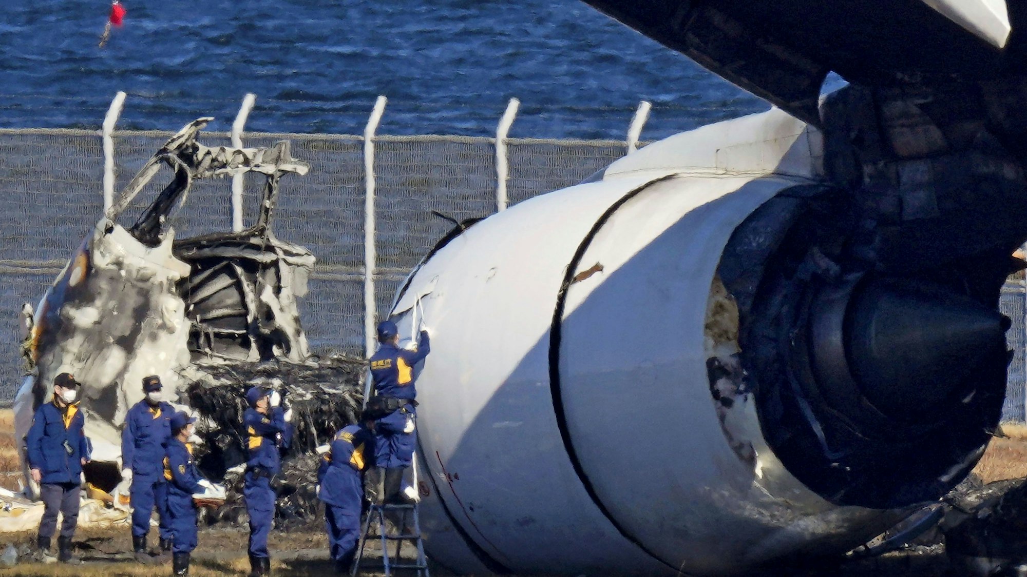Japanische Ermittler untersuchen das Wrack des Airbus A350. Die getroffene Bombardier DHC-8 wurde ebenfalls völlig zerstört. Fünf der sechs Insassen starben, der Pilot wurde lebensgefährlich verletzt.