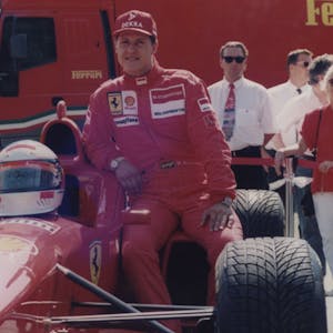 Michael Schumacher lehnt sich an einen Ferrari.