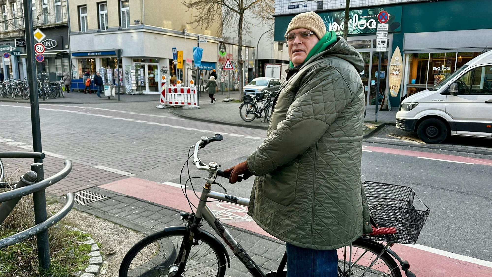 Zahnarzt Tim Bliesener steht mit seinem Fahrrad auf der Venloer Straße.