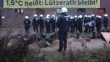 Polizisten stehen am zweiten Tag der Räumung im von Klimaaktivisten besetzten Braunkohleort Lützerath. Der Energiekonzern RWE will die unter Lützerath liegende Kohle abbaggern - dafür soll der Weiler auf dem Gebiet der Stadt Erkelenz am Braunkohletagebau Garzweiler II abgerissen werden. +++ dpa-Bildfunk +++