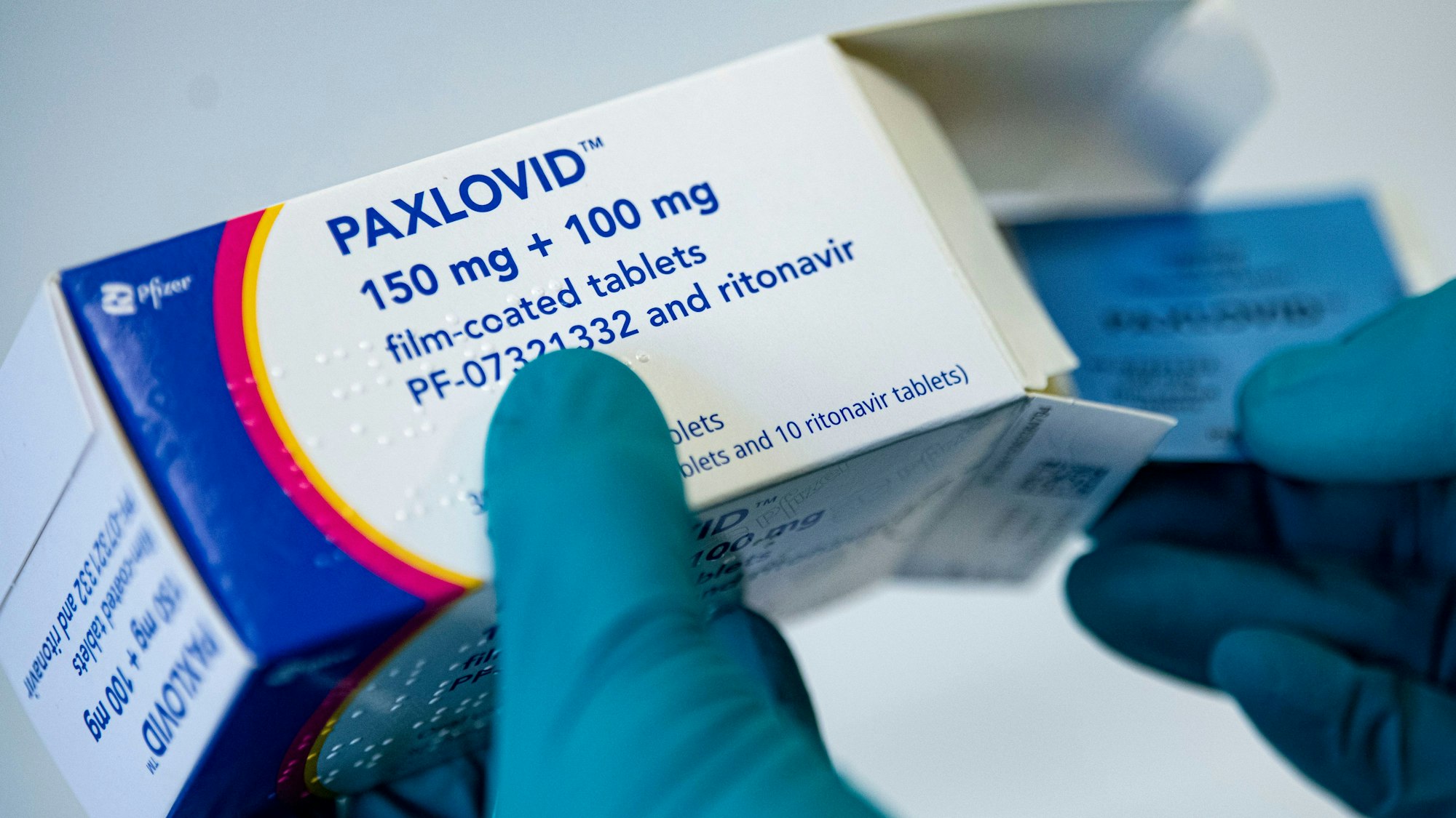 Ein Apotheker hält das Corona-Medikament Paxlovid in den Händen. Bundesweit soll es zu illegalem Weiterverkauf des Mittels gekommen sein. (Symbolbild)
