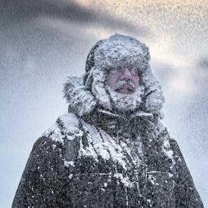 Verschneiter Mann im Winteroutfit.