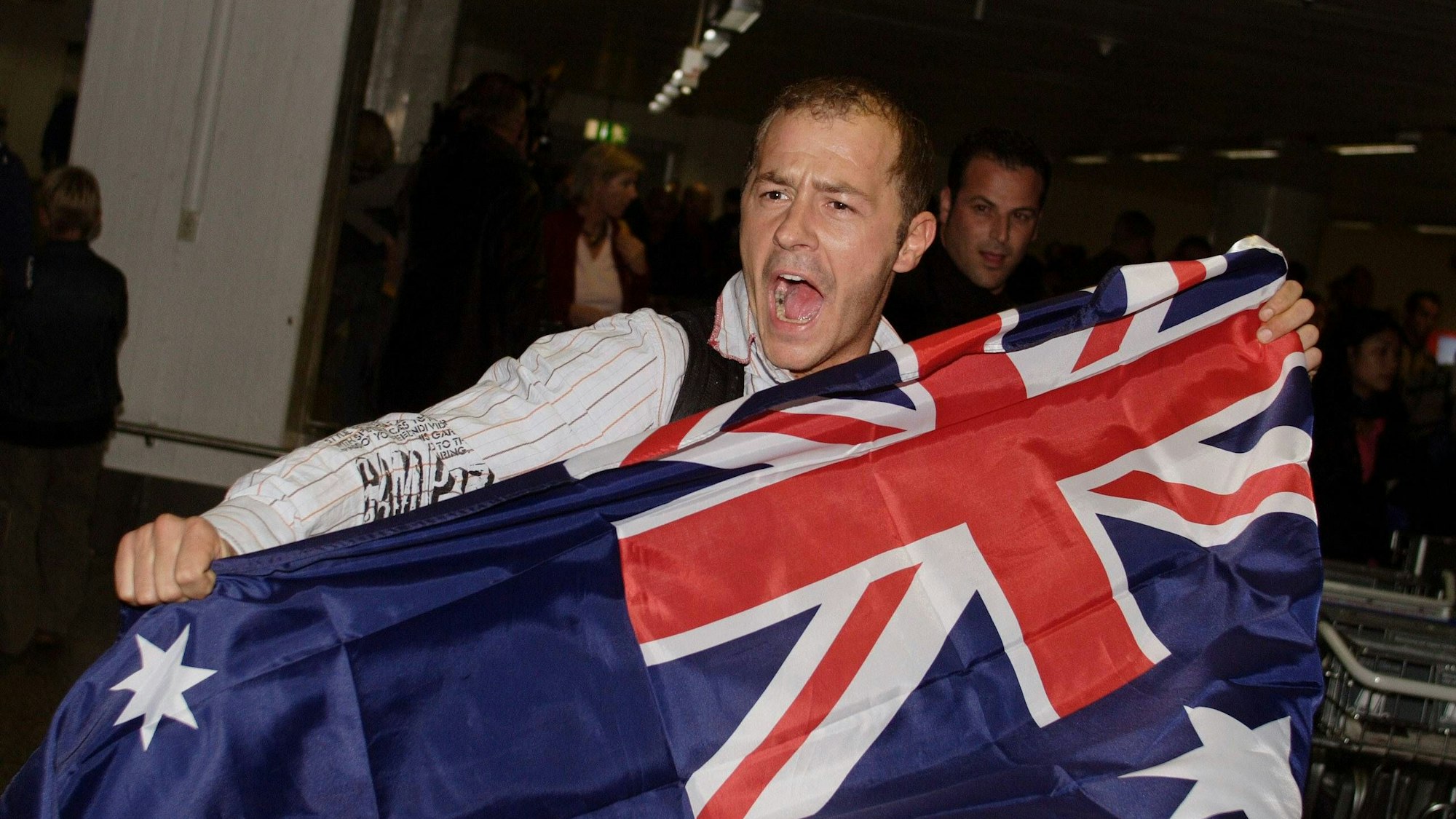Schauspieler Willi Herren (GER) mit australischer Flagge in Frankfurt am Main - Rückkehr aus dem Dschungel und Ende der RTL Fernsehshow IBES.