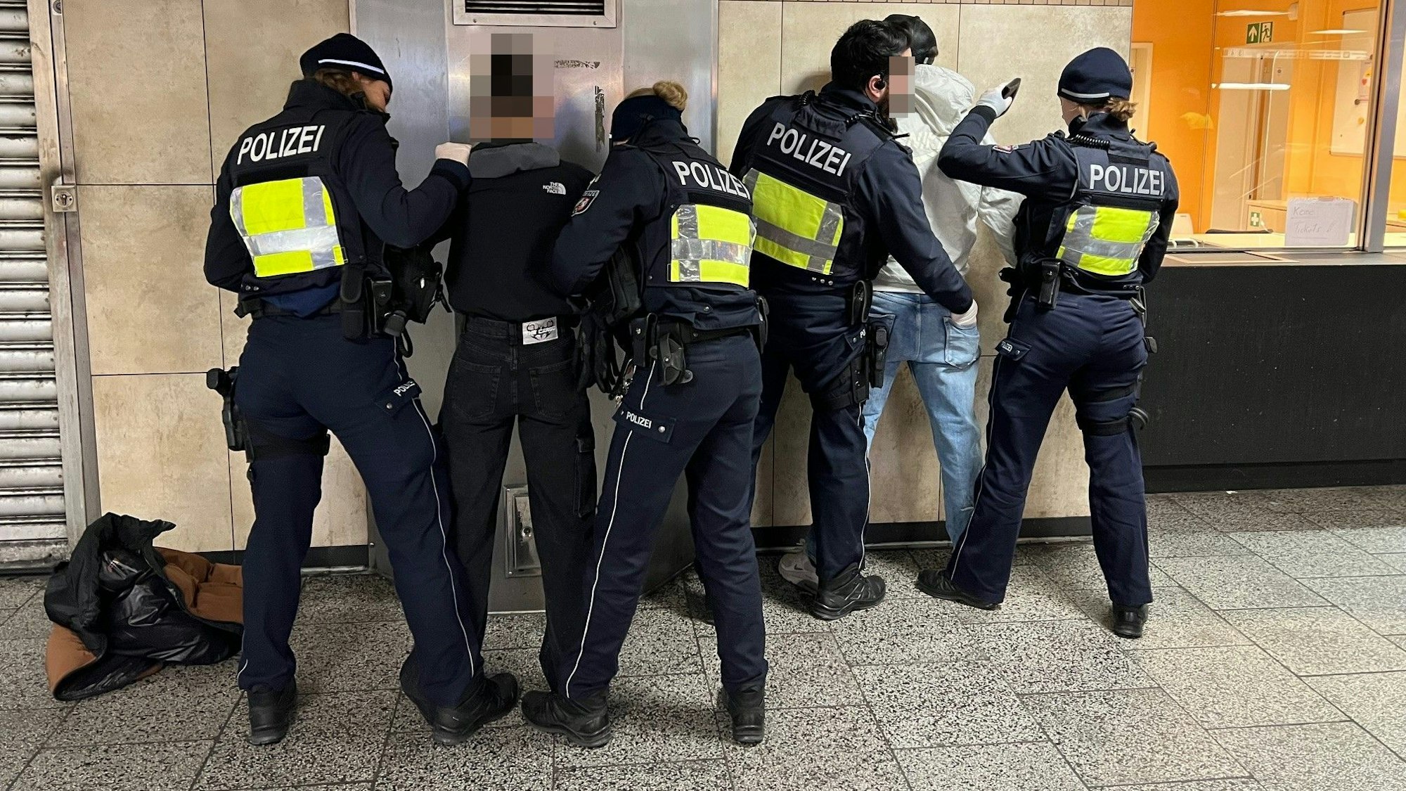 Polizistinnen und Polizisten durchsuchen in der KVB-Zwischenebene am Ebertplatz zwei mutmaßliche Drogendealer.
