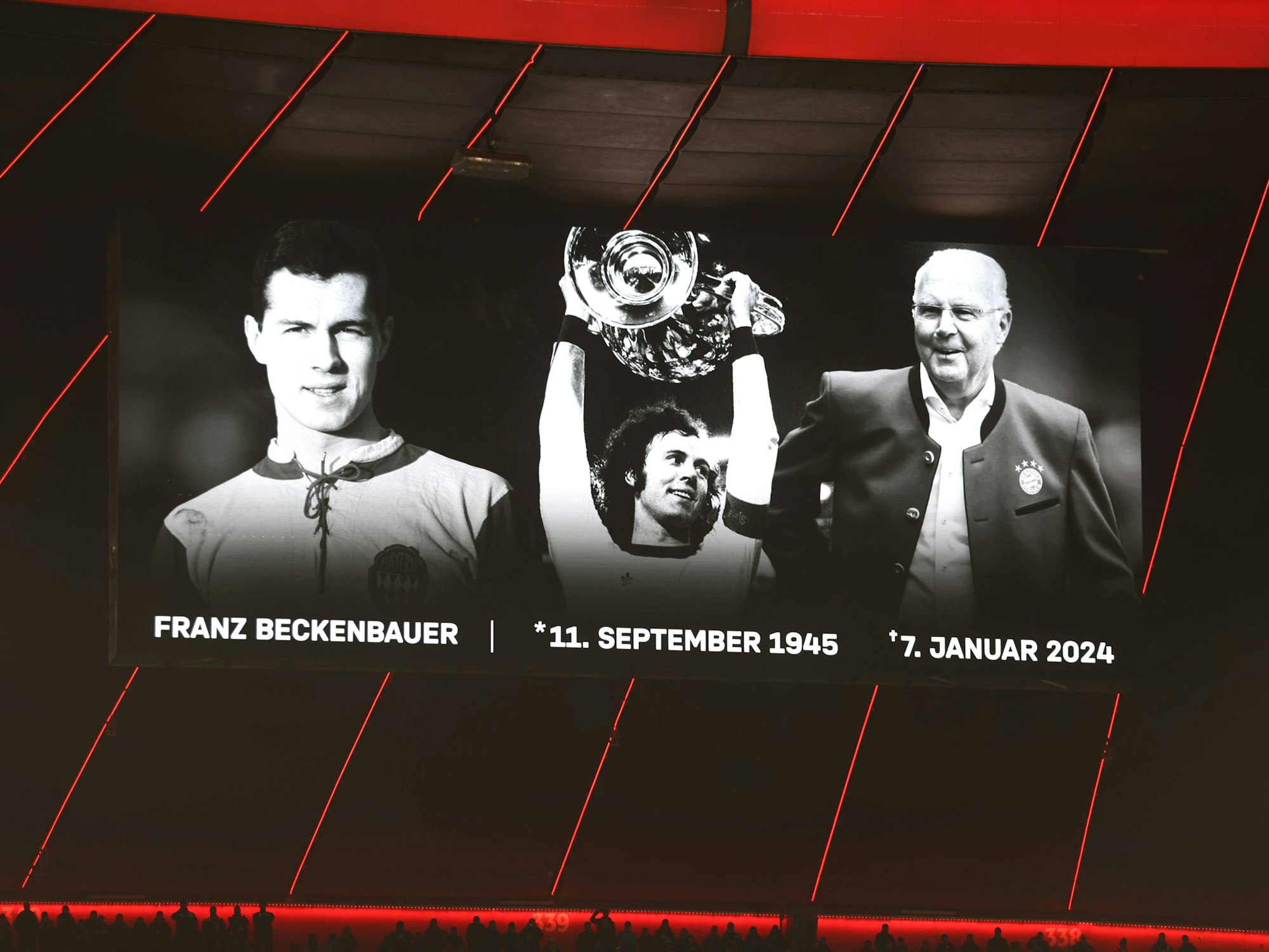 Auf der Leinwand in der Allianz-Arena sind Bilder von Franz Beckenbauer.