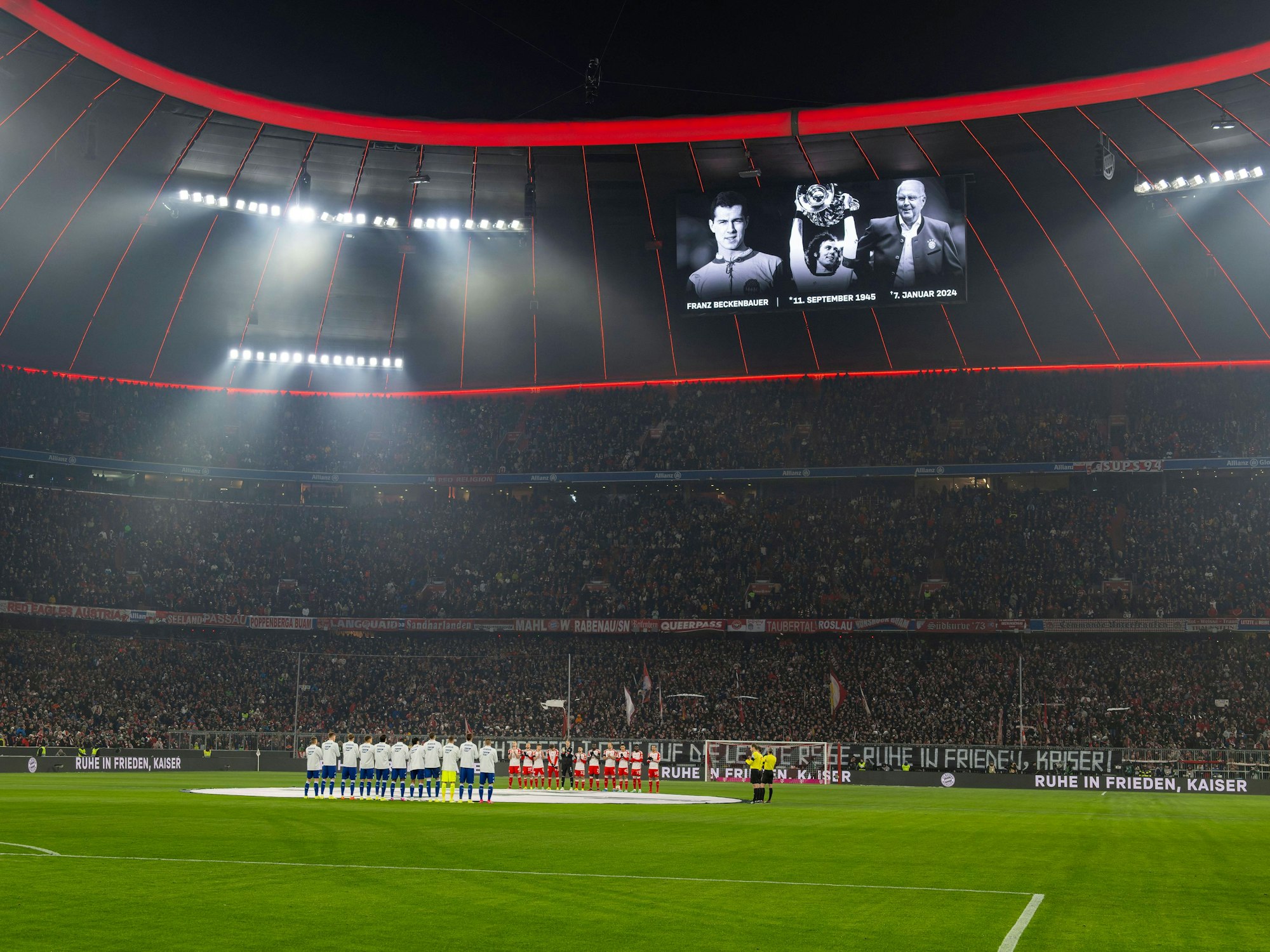 In einer Schweigeminute vor dem Spiel gedenken Fans, Spieler und Schiedsrichter an Franz Beckenbauer.