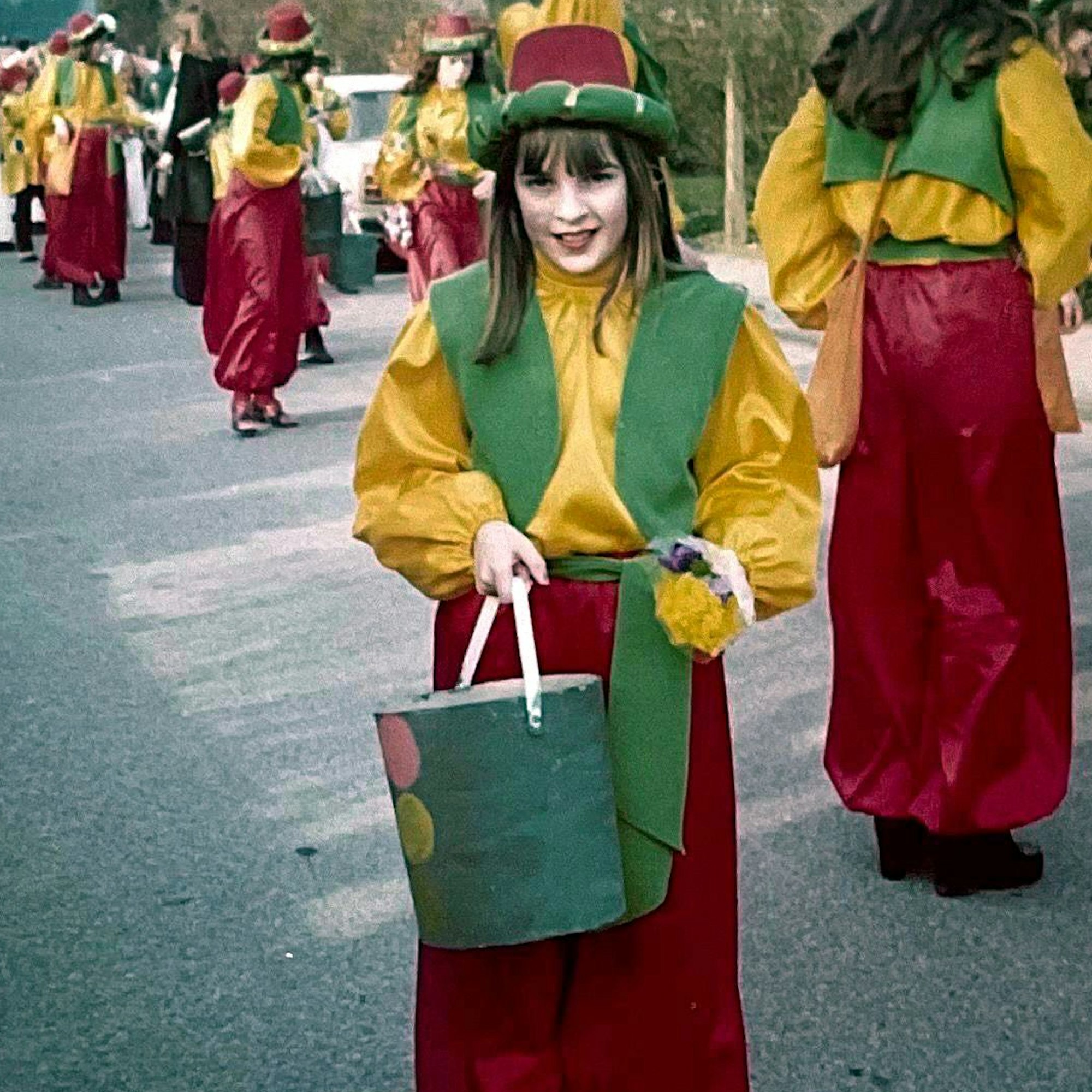 Ein Mädchen im Kostüm steht in einer Karnevalsgruppe eines Festumzugs.