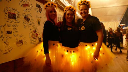 Drei Frauen als Sonnenblumen verkleidet.