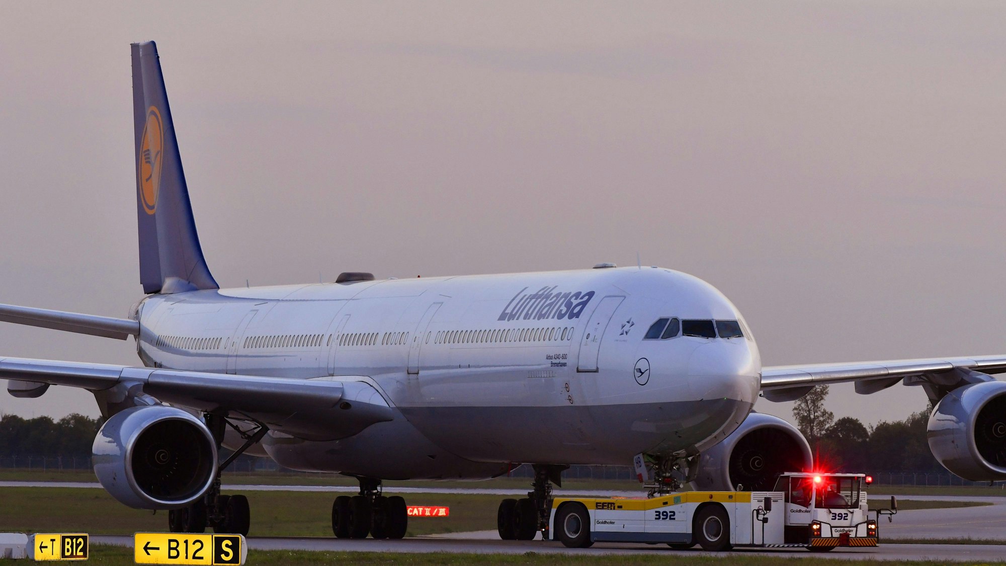 Ein Airbus A340 der Lufthansa wird auf dem Flughafen München von einem Fahrzeug gezogen. Mehrere Warnleuchten sind angeschaltet. (Symbolbild)