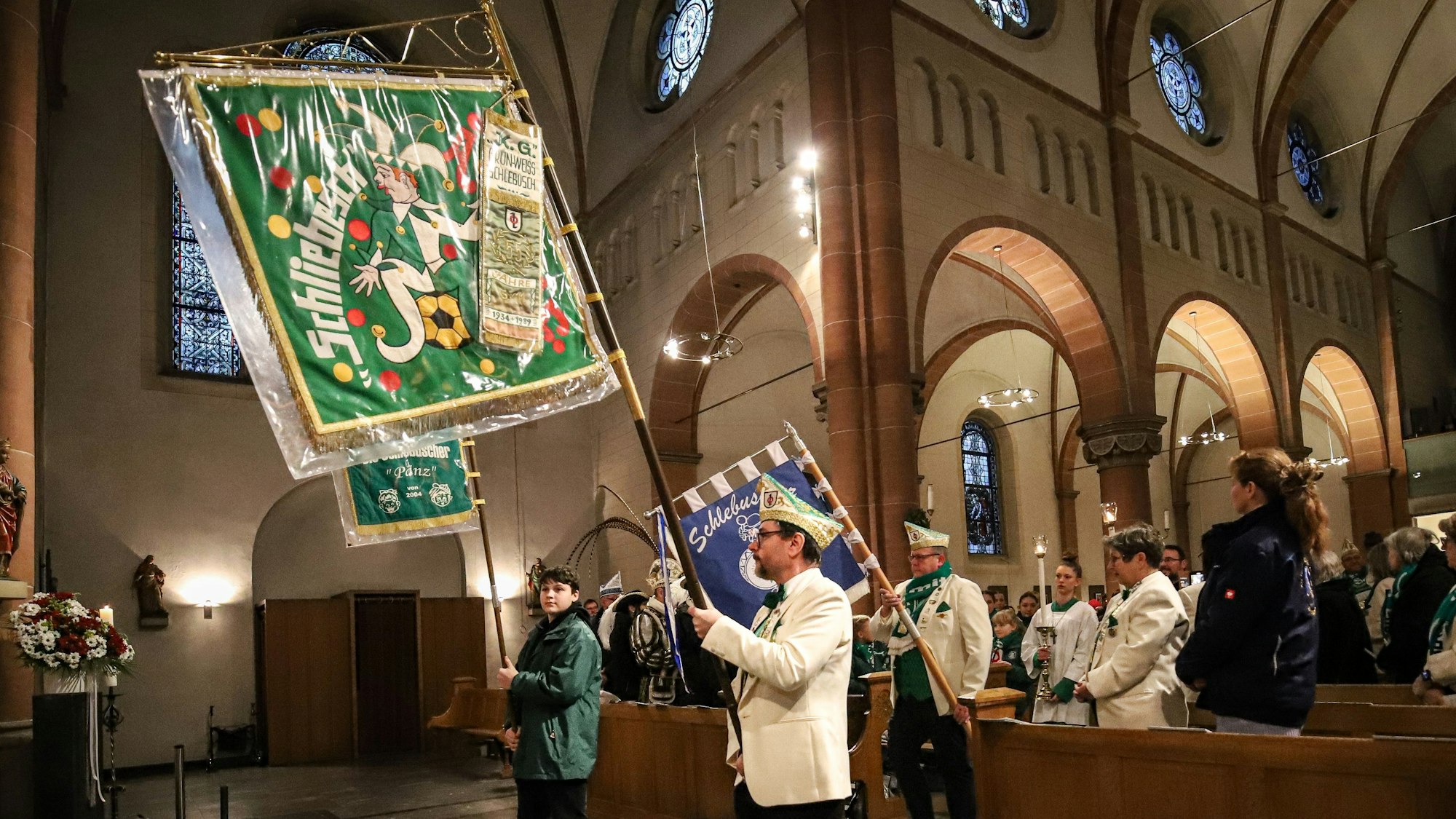 Karnevalisten mit ihren Standarten in der Kirche Sankt Andreas