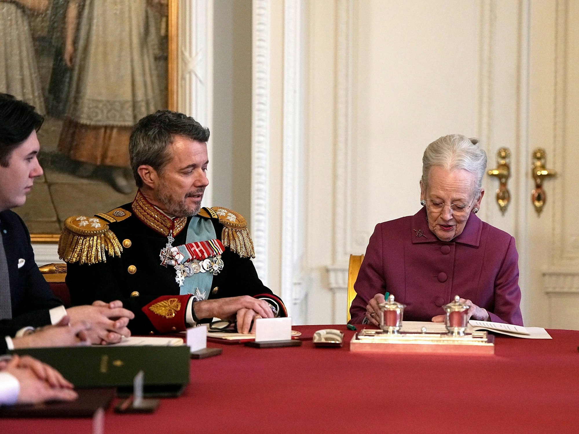 Königin Margrethe II. von Dänemark unterzeichnet im Staatsrat von Schloss Christiansborg die Abdankungserklärung. Neben ihr sitzen der neue König Frederik X. und der neue Kronprinz Christian.