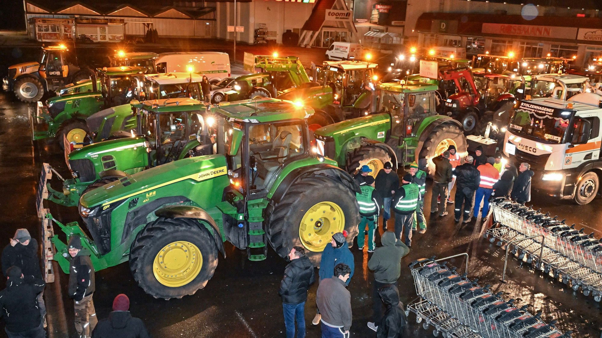 Viele Traktoren von Landwirten stehen am frühen Montagmorgen auf einem Parkplatz, um sich für ihre Fahrt in Richtung Berlin zu sammeln.